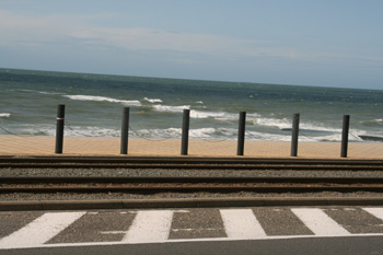 Tram rail separating road from beach